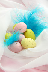 Fototapeta na wymiar Beautiful easter eggs and decorative feathers, close up