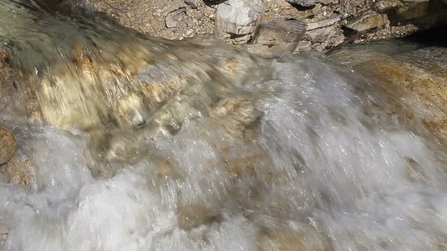 stream of water between the rocks in the mountains