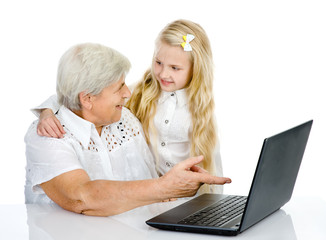 girl teaching and showing computer to her grandmother