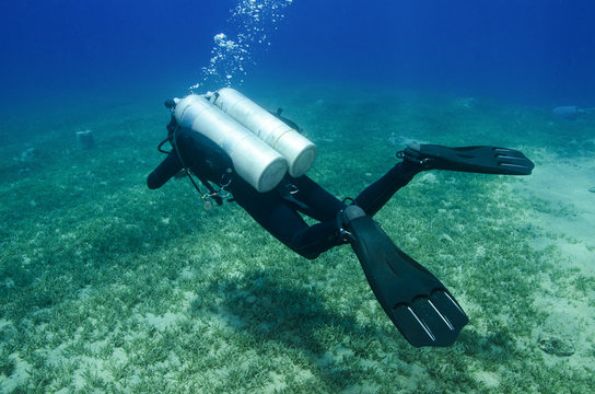 Girl Scuba Dives In Clear Blue Water With Twin Tanks