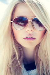 Naklejka premium portrait of a beautiful girl in glasses close up