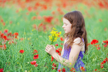 kleines mädchen riecht an blumen