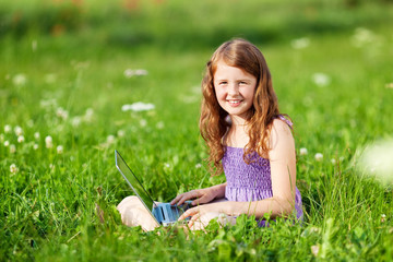 mädchen sitzt mit laptop draußen