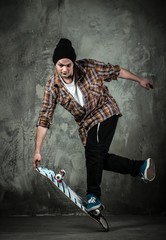 Young man in hat and shirt performing stunt on skateboard