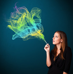 Obraz premium Pretty lady smoking cigarette with colorful smoke