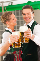 Man and woman with beer glass in brewery