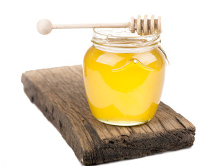 Honey in bank on wooden boards isolated by the white