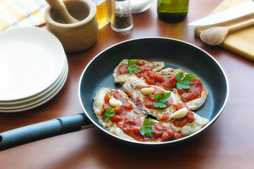 Preparation of pork chops with tomato, garlic, parsley, olive oil and pepper, in a paddle