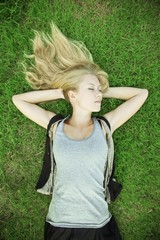 Portrait of a blonde girl lying on grass