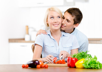 Obraz na płótnie Canvas Man kisses girl while she is cooking 