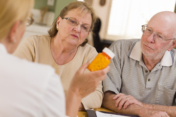 Doctor or Nurse Explaining Prescription Medicine to Senior Coupl