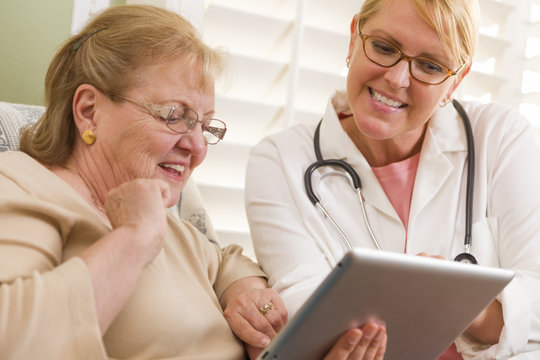 Doctor or Nurse Talking to Senior Woman with Touch Pad