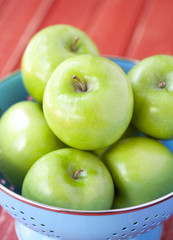 Green apples in a blue colander