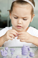 The child sculpts from clay