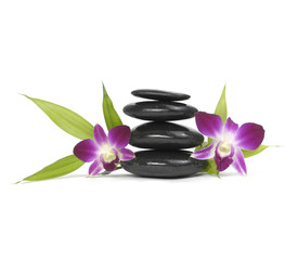 Stacked zen stones with pink orchid and bamboo leaf