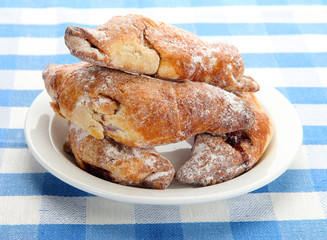 Taste croissants on plate, on tablecloth.