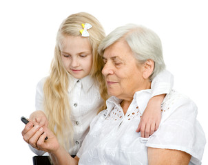granddaughter showing and teaching a mobile phone to her grandmo