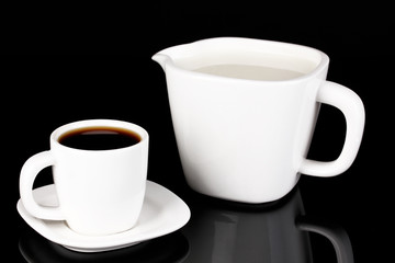 A cup of strong coffee and sweet cream isolated on black