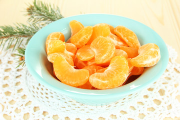 Tasty mandarine's slices on color plate on light background