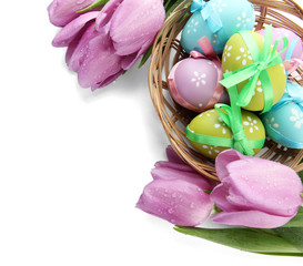 Bright easter eggs in basket and tulips, isolated on white