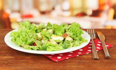 Caesar salad on white plate, on bright background