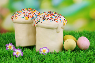 Fototapeta premium Easter cake with sugar glaze and eggs on grass