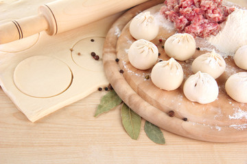 Raw dumplings, ingredients and dough, on wooden table