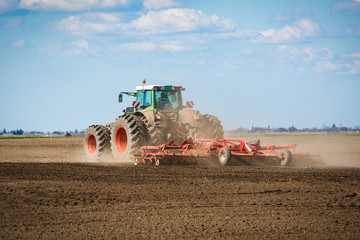 Fototapeta premium Tractor in the field sow