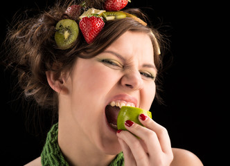 young woman eating a sour fruit and have something fruits on the