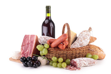 wicker basket with sausages, ham and wine