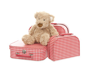 three vintage red and white suitcases with teddy bear