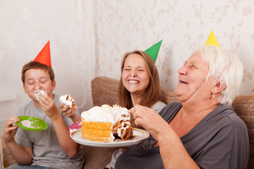 Senior woman and its grandsons with birthday cake