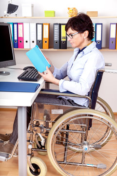 Sitting in a wheelchair working at desk