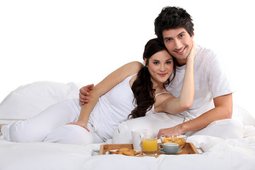 Obraz na płótnie Canvas a couple having breakfast on bed
