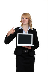 Businesswoman holding a laptop and giving the thumb's up