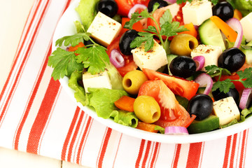 Greek salad in plate on napkin close up