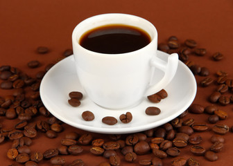 Cup of strong coffee on brown background