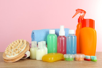 Hotel amenities kit on table on pink background