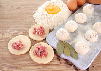 Raw dumplings, ingredients and dough, on wooden table