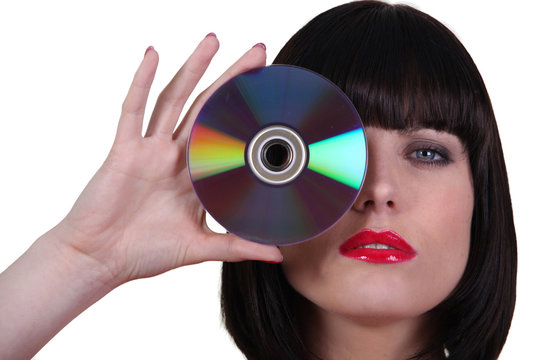 Woman holding a cd to an her eye