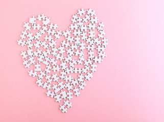 puzzle made heart sharp on pink background