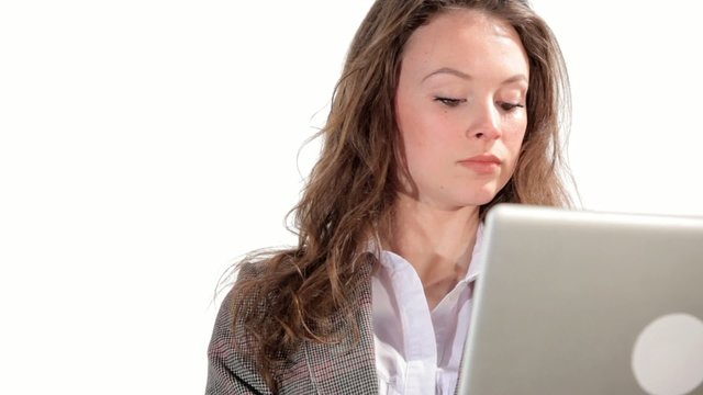 Gorgeous businesswoman typing on laptop on white background