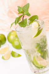 Iced Lime Mojito cocktail  close-up with straw hat background
