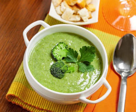 Broccoli cream soup on table, top view