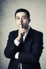 Business man with finger on lips asking for silence - 51547131