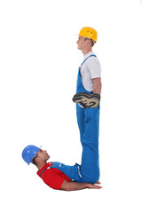 Two builders forming the letter J