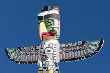 A totem wood pole in the blue cloudy background