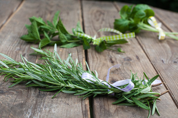 Rosemary, basil and pepermint plants on wooden table