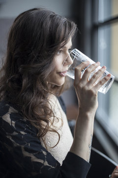 Young Woman Drinking A Pint Glass Of Ice Water