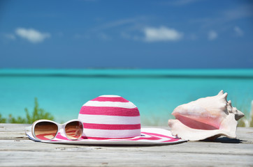 Fototapeta na wymiar Okulary przeciwsłoneczne, kapelusz i powłoki przed ocean. Exuma, Bahamy